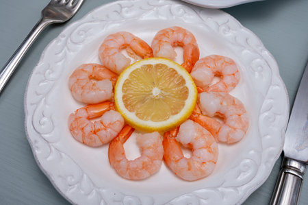 Catch of the day, fresh cooked shrimps served with lemon and garlic sauce on white plate in seafood restaurantの写真素材
