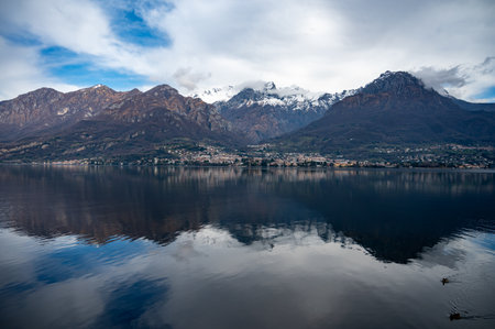 Driving car on road along shores of Lake Como in Northern Italy, spring sunny days, views of alpine mountains, water and villagesの写真素材