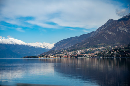 Driving car on road along shores of Lake Como in Northern Italy, spring sunny days, views of alpine mountains, water and villagesの写真素材