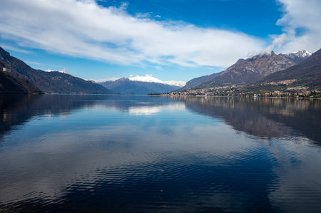 Driving car on road along shores of Lake Como in Northern Italy, spring sunny days, views of alpine mountains, water and villagesの写真素材