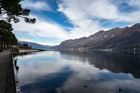 Driving car on road along shores of Lake Como in Northern Italy, spring sunny days, views of alpine mountains, water and villagesの写真素材