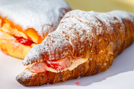 Dutch cuisine, fresh baked strawberry cake and croissant with cream and fresh fruits served in outdoor cafeの写真素材
