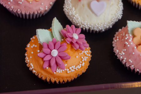 Colorful marzipan almongs cakes with decorative marzipan flowers on displayの写真素材