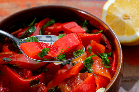 Grilled red peppers, sweet paprika salad with fresh garlic and parsley, tasty vegetablesの写真素材