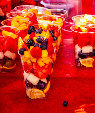 Healthy snack, dessert, colorful fresh fruits and berries cutted in pieces and served in plastic glass, street food, portobello road market, Londonの写真素材