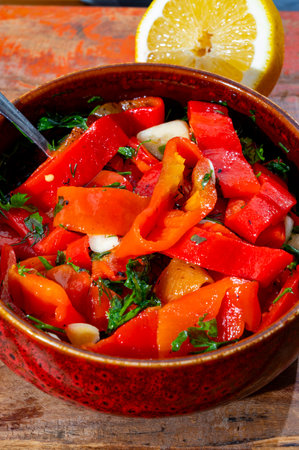 Grilled red peppers, sweet paprika salad with fresh garlic and parsley, tasty vegetablesの写真素材