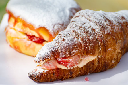 Dutch cuisine, fresh baked strawberry cake and croissant with cream and fresh fruits served in outdoor cafeの写真素材
