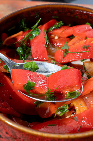 Grilled red peppers, sweet paprika salad with fresh garlic and parsley, tasty vegetablesの写真素材