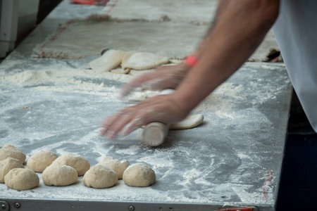 Making of flat pita bread from wheat on street market
