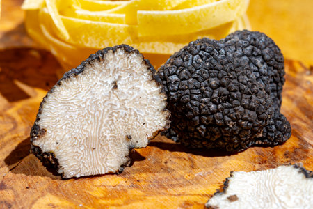 Cooking with black summer truffle, tasty aromatic mushroom on wooden boardの写真素材
