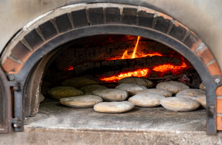 Baking of flat pita bread in wood-fired oven on local street marketの写真素材