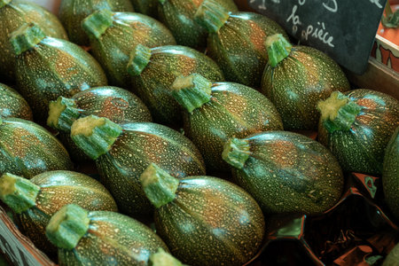 Fresh green round zucchini vegetables background close up on French farmers market