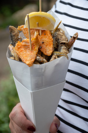 Italian street food, variety of catch of the day fish deep fried in paper cone, seafood