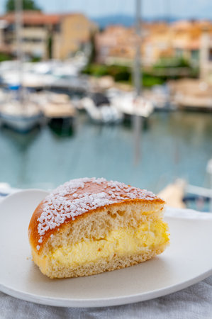 Cake of French Riviera, Tarte Tropezienne cake in yacht harbor of Port Grimaud, summer vacation in Provence, France, close upの写真素材