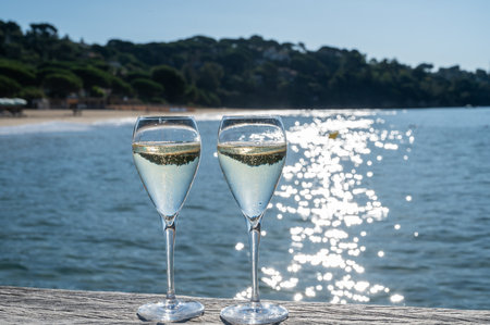 Summer time in Provence, two glasses of cold champagne cremant sparkling wine on famous Pampelonne white sandy beach near Saint-Tropez in sunny day, Var department, France, beach club partyの写真素材