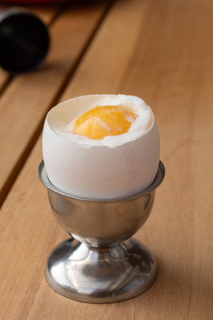 Soft-boiled organic free range bio chicken egg served on egg holder for nutritious breakfastの写真素材