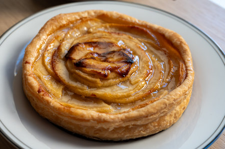 French fresh baked sweet puff pastry with fresh apple fruits in syrup in confectionery shop close up