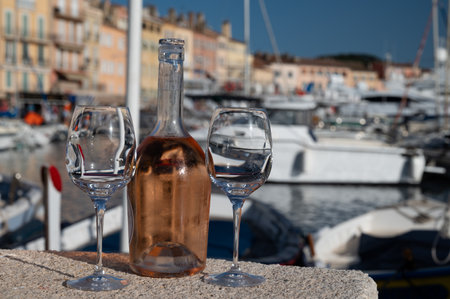 Glasses of cold french rose Cote de Provence wine in old fisherman boats port and yachts harbor in Saint-Tropez, summer vacation on French Riviera in Provence, Franceの写真素材