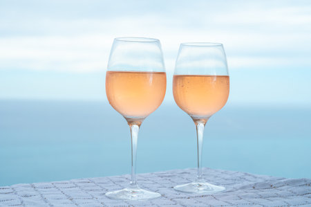 Summer time in Provence, two glasses of cold rose wine with blue sea view on background, French Riviera near Menton and Monaco, south of Franceの写真素材