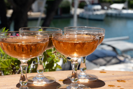 French brut rose champagne sparkling wine in coupe glasses in yacht harbor of Port Grimaud near Saint-Tropez, French Riviera vacation, Var, France is summerの写真素材