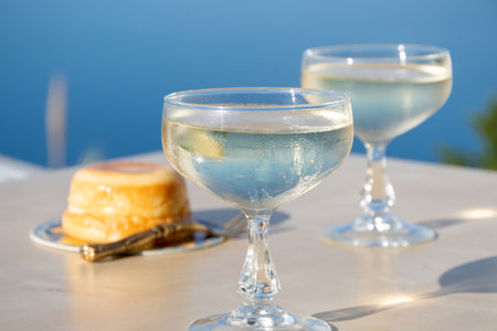Cold sparkling wine, cava or champagne in two coupe glasses on table with blue sea view, French Riviera is summer, Franceの写真素材