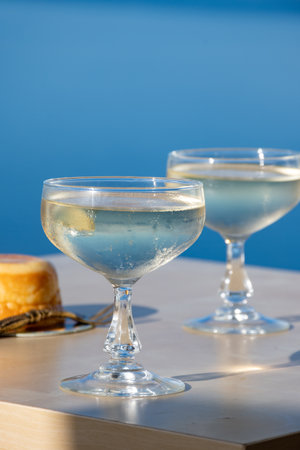 Cold sparkling wine, cava or champagne in two coupe glasses on table with blue sea view, French Riviera is summer, Franceの写真素材