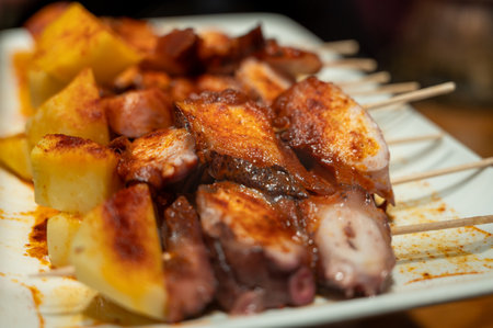 Typical snacks of Basque Country, pinchos or pinxtos skewers with small pieces of bread, fish, sea food, sweet green pepper served in bar in San-Sebastian or Bilbao, Spain, close upの写真素材