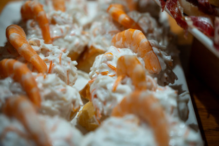 Typical snacks of Basque Country, pinchos or pinxtos skewers with small pieces of bread, fish, sea food, sweet green pepper served in bar in San-Sebastian or Bilbao, Spain, close upの写真素材