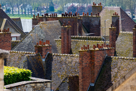 Views of tiled roofs and chimneys of houses in old part of town of Gien is on the Loire river, in...