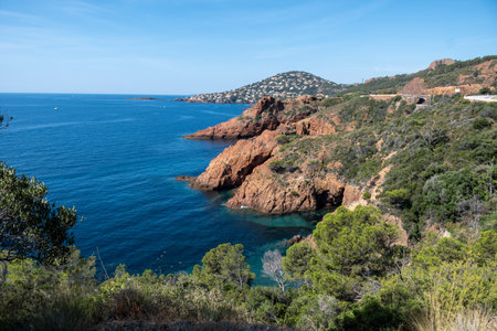 Views along Corniche d'Or or Corniche de l'Esterel beautiful coastal road, crystalline blue sea and sky combined with reddish color of Massif de l'Esterel mountains, travel destination in France, French Rivieraの写真素材