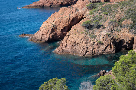 Views along Corniche d'Or or Corniche de l'Esterel beautiful coastal road, crystalline blue sea and sky combined with reddish color of Massif de l'Esterel mountains, travel destination in France, French Rivieraの写真素材