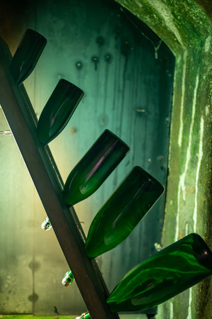 Champagne bottles on pupitre riddling racks in deep and long underground caves, traditional method...