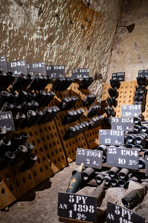 Champagne bottles on pupitre riddling racks in deep and long underground caves, traditional method...