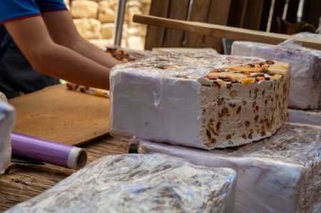 Fresh dessert traditional white nougat with chocolate, nuts and fruits on local farmers market in Montellimar, Franceの写真素材