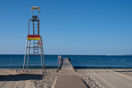 Morning view on crystal clear blue water and pier of Plage du Debarquement white sandy beach near...