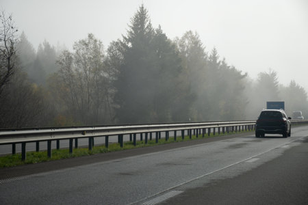 Driving car on road in Belgium, fog in Ardennes, nature park, Walloniaの写真素材