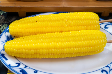 Steamed or boiled sweet corn in asian food court on weekly market, vegetarian asian foodの写真素材