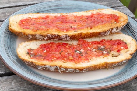 Traditional andalusian breakfast on roof patio with bread toasts, fresh ground tomatoes sauce and olive oil, Sevilla, Andalusia, south of Spainの写真素材