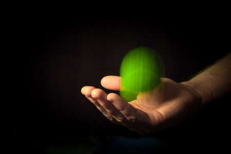 A hand catching a green tennis ball.の写真素材