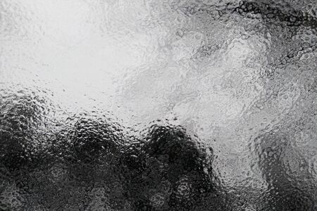 An icy glass window at sunrise early in the winter morning. Ice on the glass.の写真素材