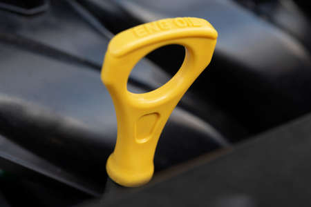Yellow oil dipstick in a car engine. Measuring the engine oil level. Oil dipstick for checking the engine oil level in the engine system.の写真素材