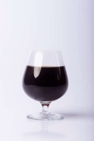 A set of a glass with red wine and peaches. A glass of red wine.