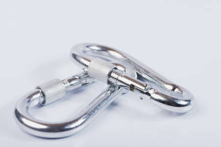 Metal snap hooks on a white isolated background. Spring carabiner made of stainless steel, heavy duty carabiner with quick release lock.の写真素材