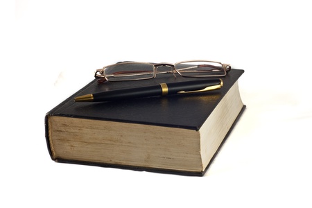 Pen and glasses on a book isolated on white.の写真素材