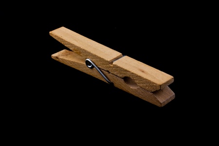 Wooden clothes peg isolated on a black background.の写真素材