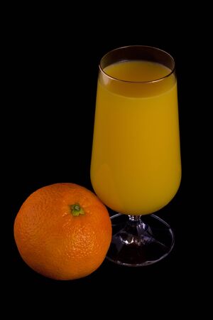 Glass of orange juice and orange isolated on black.の写真素材