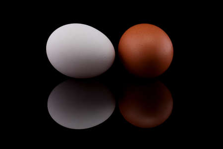 Two chicken eggs isolated on black background の写真素材