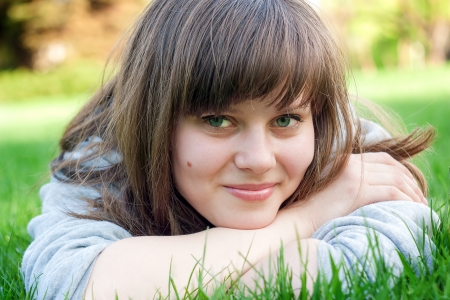 Pretty girl lying on the grass in the park の写真素材