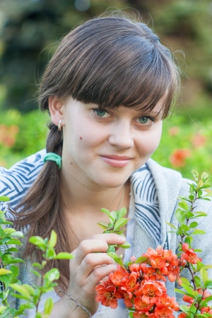 Portrait of a young pretty girl near the blooming flowers の写真素材