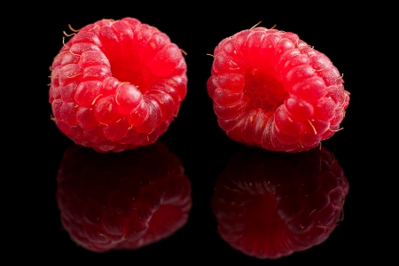 Two ripe raspberry on black background の写真素材